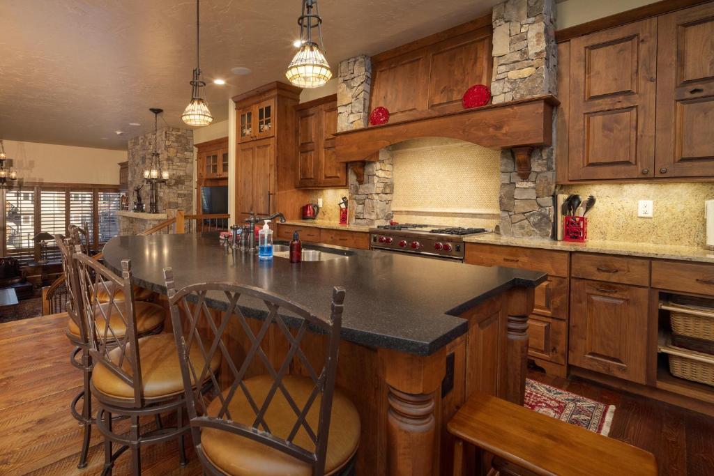 a kitchen with wooden cabinets and a large island with chairs at Base Camp at Iron Horse,,, townhouse in Winter Park