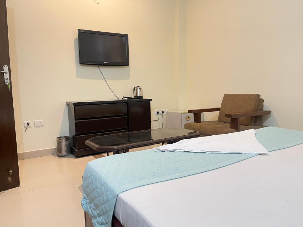 a bedroom with a bed and a tv on the wall at Aadi's Residency in Gurgaon