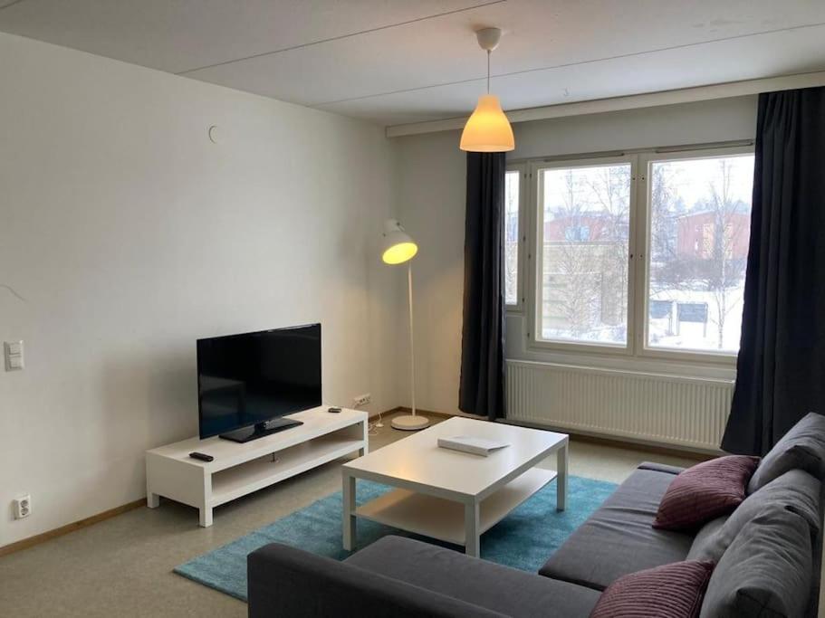 sala de estar con sofá y TV en Kotimaailma - Kalustettu saunallinen asunto kuudelle en Vantaa