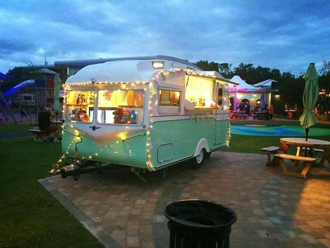 an old green and white food truck decorated with lights at Claire's Retreat, Rudd Lake, Tattershall Lakes in Tattershall