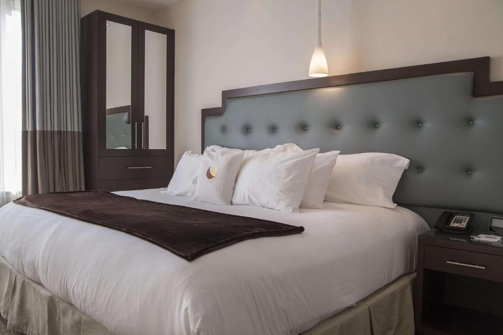 1 dormitorio con 1 cama grande con almohadas blancas en Condor Hotel by LuxUrban en Brooklyn