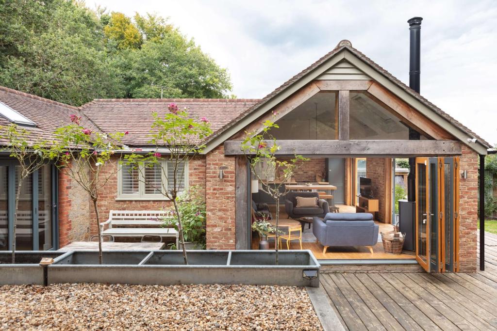 an extension to a brick house with a deck at Badgers Cottage in Fittleworth