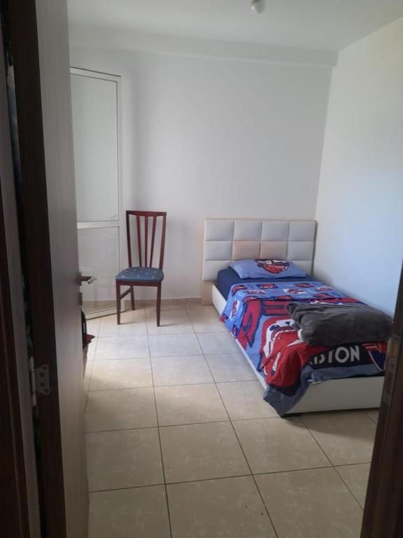 ein Schlafzimmer mit einem Bett und einem Stuhl in der Unterkunft تطوان in Tétouan