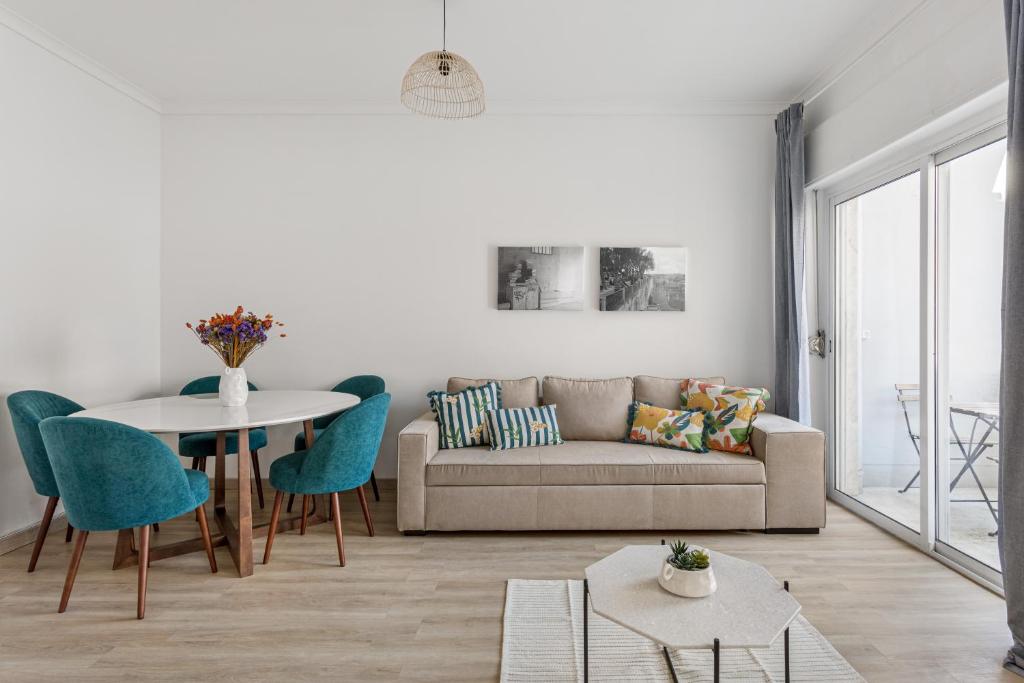 ein Wohnzimmer mit einem Sofa und einem Tisch in der Unterkunft ALTIDO Striking flat in Benfica in Lissabon