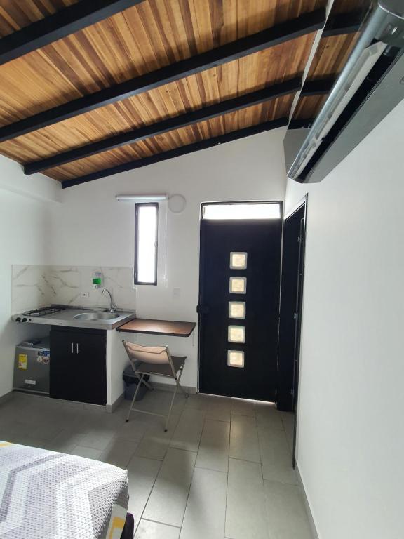 eine Küche mit einer schwarzen Tür und einem Tisch in der Unterkunft Aptoestudio full equipado y excelente ubicación in Cúcuta