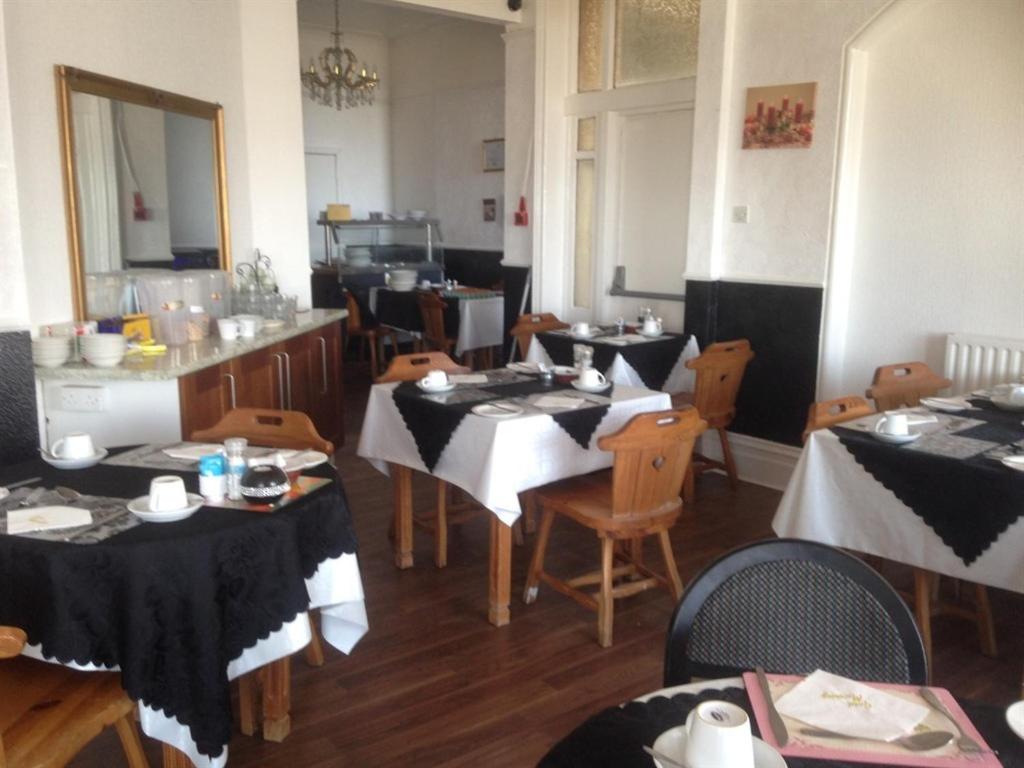 a restaurant with tables and chairs with black and white table cloth at Anzy Panzy Hotel and Apartments in Blackpool