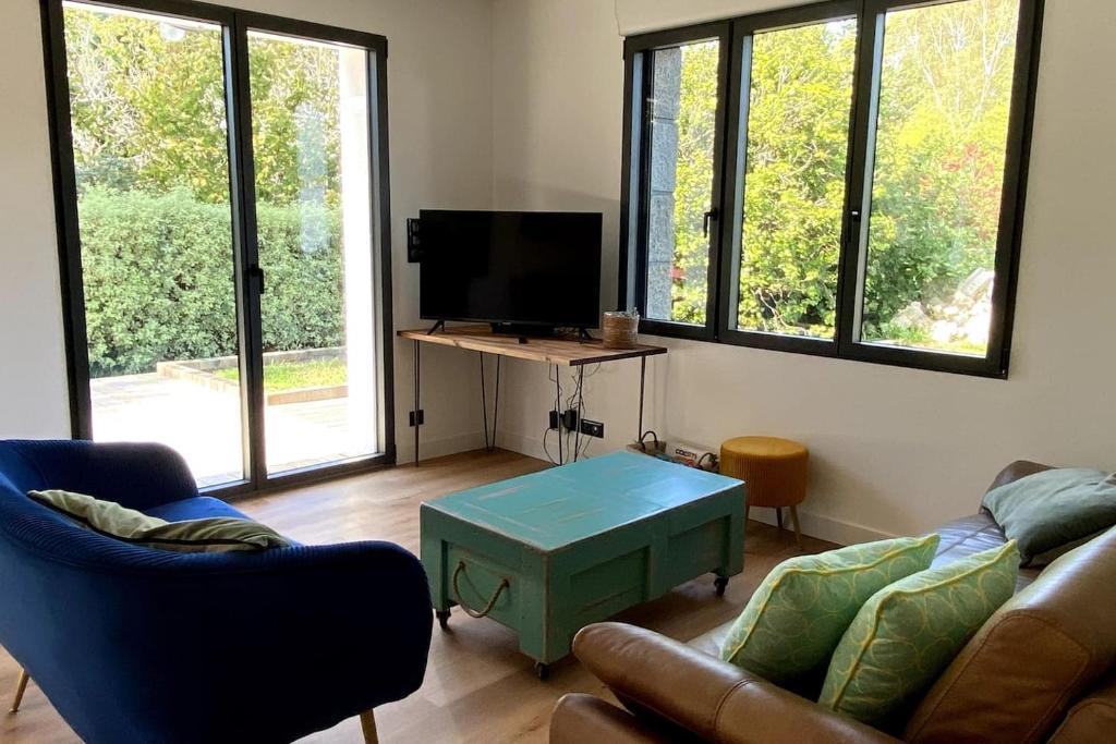 sala de estar con sofá, TV y mesa en Maison proche plages, en Clohars-Fouesnant