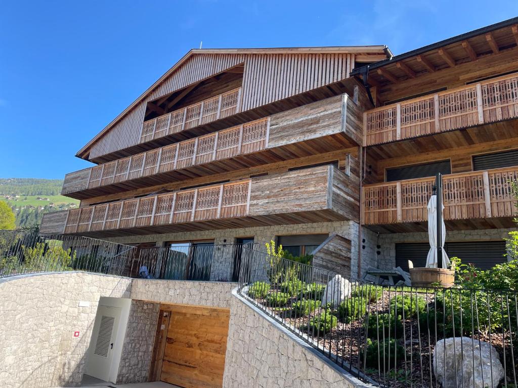 a large wooden building with a balcony at Exclusives Apartment im Sonnenhof Moos in Sesto