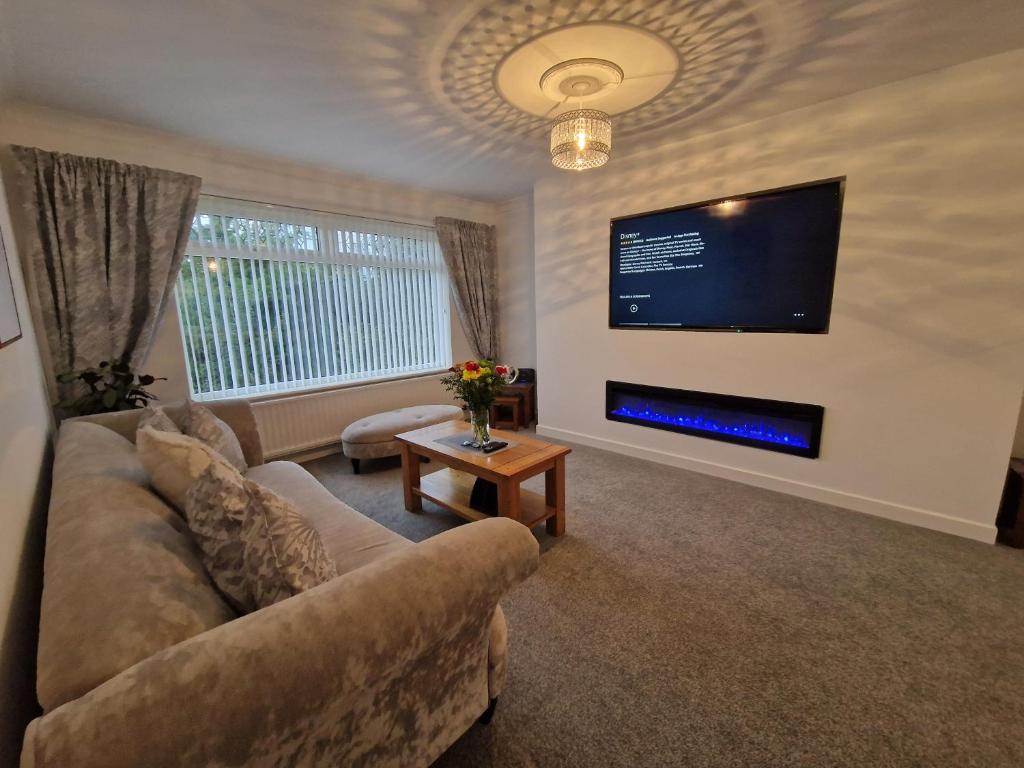 uma sala de estar com um sofá e uma televisão de ecrã plano em Lakeside 3 Bedroom Bungalow Retreat Merthyr Tydfil em Cefn-coed-y-cymmer