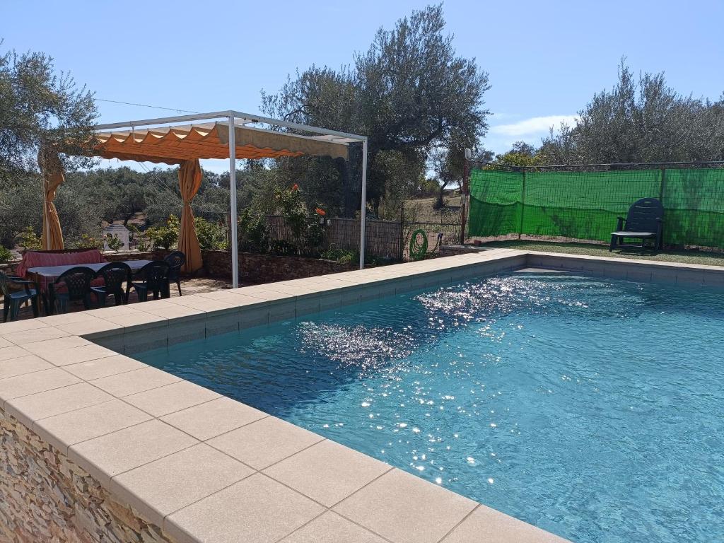 una piscina en un patio con mesa y sombrilla en Finca el Berezal, en Aracena