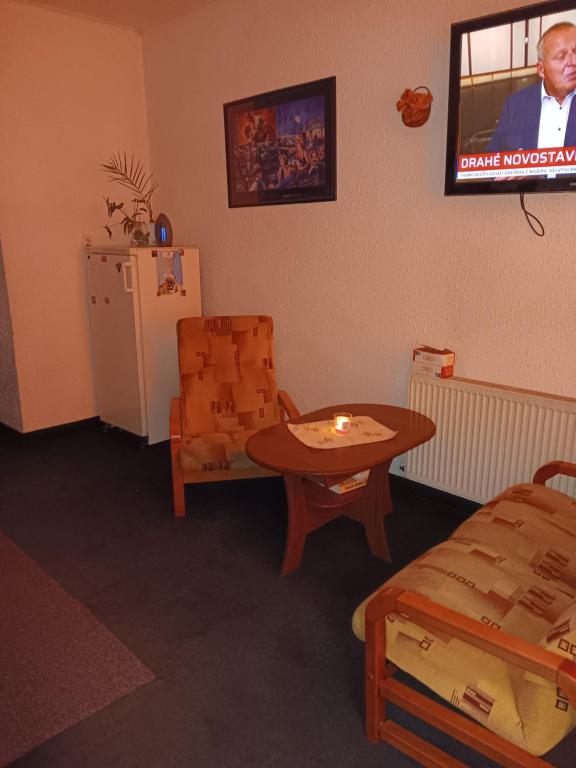een kamer met een tafel, een stoel en een tv bij Ubytovna u hospůdky in Ostrava