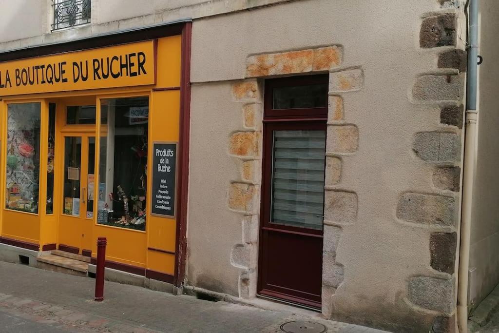 un magasin dans une rue avec une vitrine jaune dans l'établissement Maison Chaleureuse dans petite cité de caractère, à Fresnay-sur-Sarthe