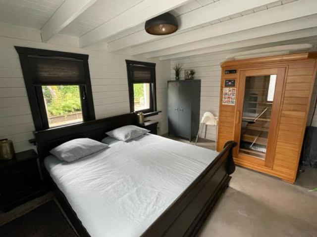 een slaapkamer met een groot wit bed met 2 kussens bij De Genten 2 in Ermelo