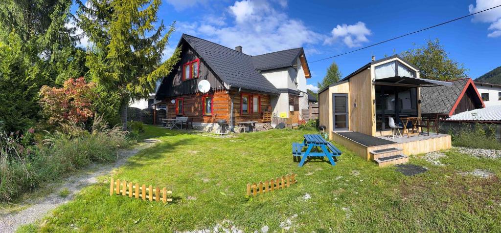 una casa con un patio con un banco azul delante de ella en Chata Górala Centralny Szczyrk en Szczyrk
