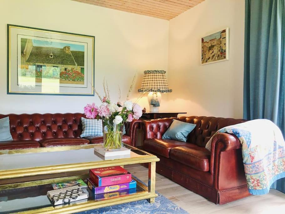 a living room with a brown leather couch and a table at Gästehaus im Garten in Zeitlofs