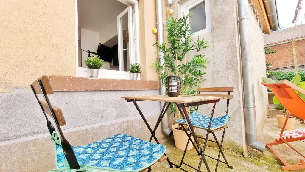 a small table and two chairs on a patio at Le Ptit Paradis - Calme - Wifi - Cour privée - Relax BNB in Mulhouse