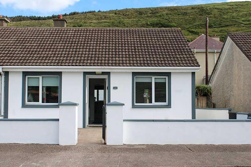 a white house with a dog in the window at 2 BEDROOM The White House in Cahersiveen