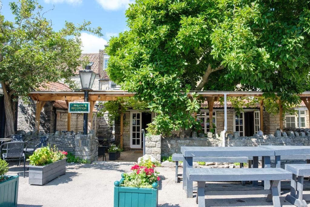 a group of picnic tables in front of a building at Mullions 51 B&B in Street