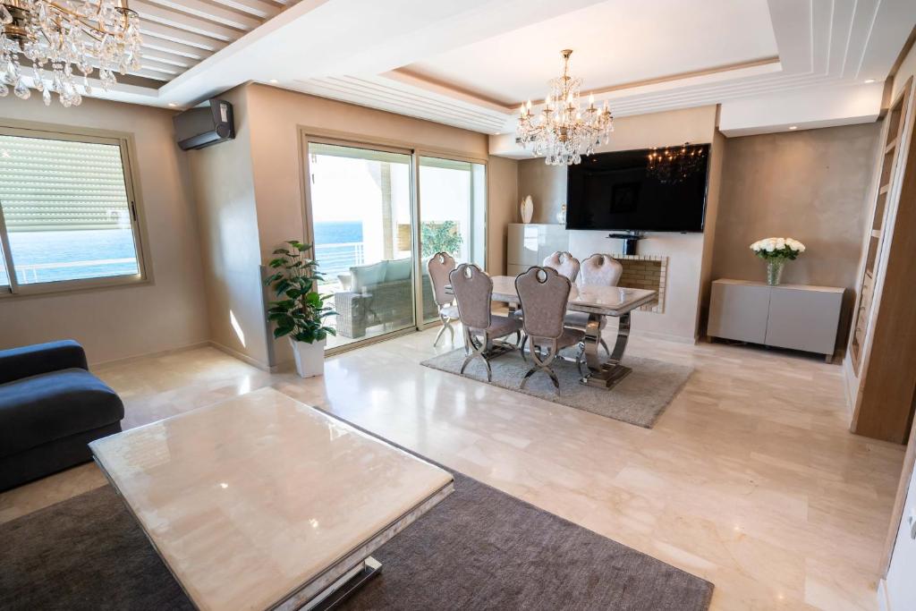 a living room with a table and a dining room at Appartement bord de mer +piscine in Tangier