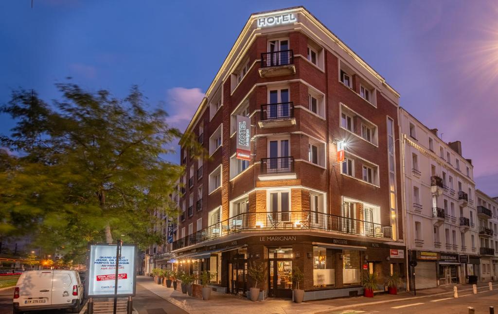 a building on a street with a van parked in front at The Originals Boutique, Hôtel Le Marignan,Le Havre Centre Gare in Le Havre