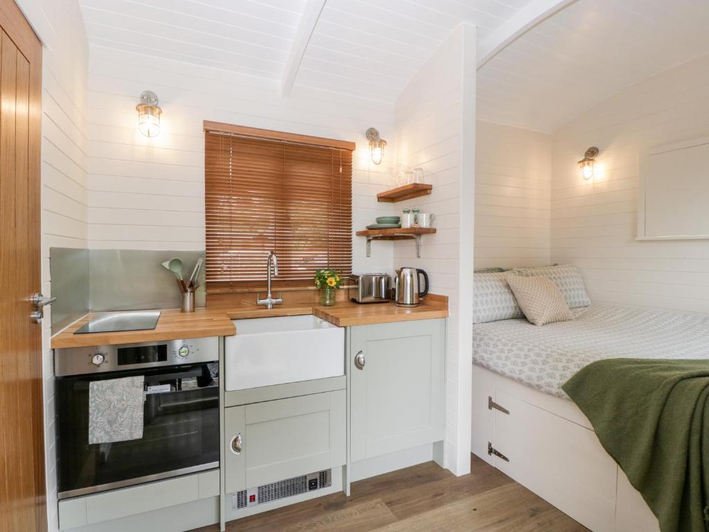 een kleine keuken met een bed in een kleine kamer bij Hazel in Cirencester