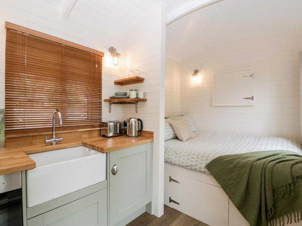 a kitchen with a sink and a bed in a room at Beech in Kemble