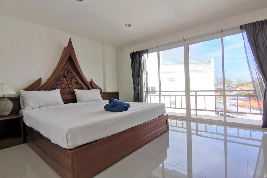 - une chambre avec un grand lit et une grande fenêtre dans l'établissement Sure Guesthouse, à Kamala Beach