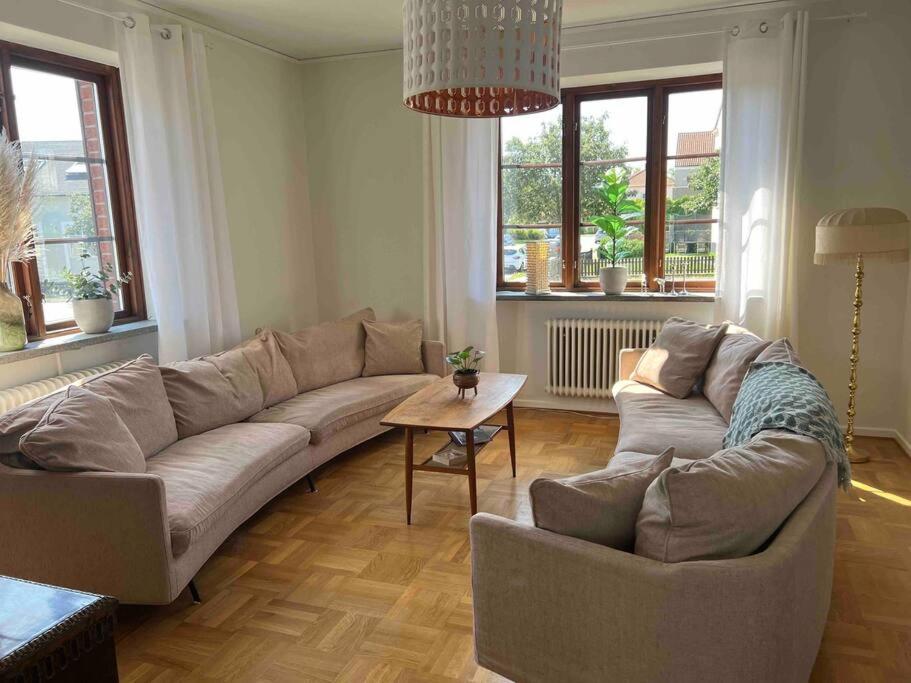 KvarteretSkatan! في إيستاد: غرفة معيشة مع أريكة كبيرة وطاولة