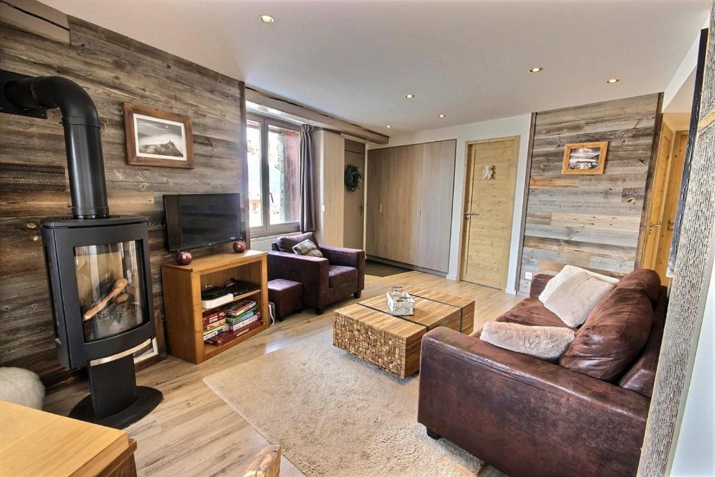 un salon avec un canapé et une cheminée dans l'établissement Le Bouquetin for 8 person, à Aime La Plagne