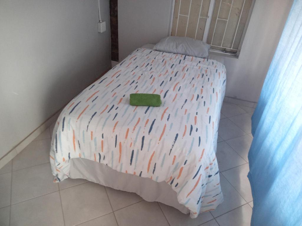 1 dormitorio con 1 cama con un edredón colorido en Las Palmas Day & Night Guest House, en Pretoria