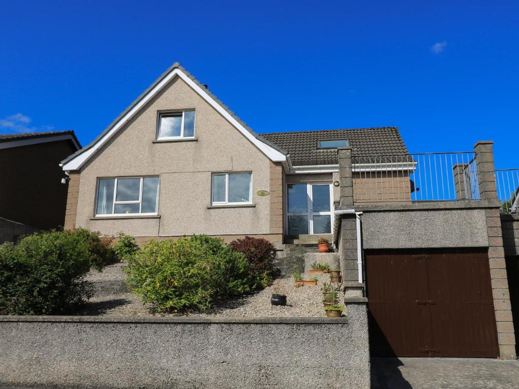 a brick house with a brown garage at Dunard Villa in Stornoway