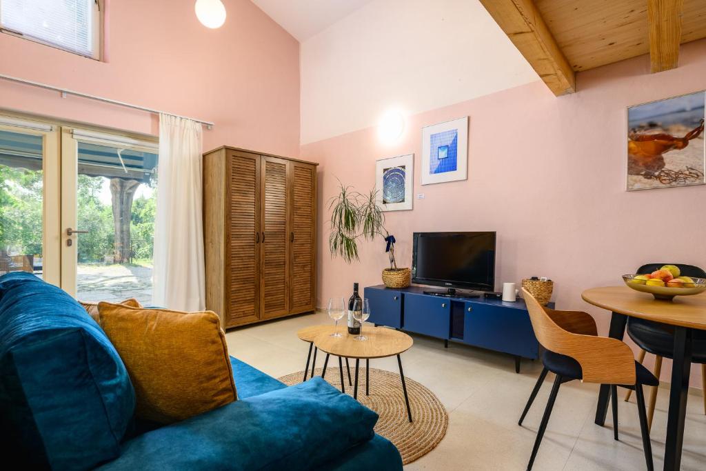 een woonkamer met een blauwe bank en een tv bij Stella Marina Deluxe Apartment in Poreč