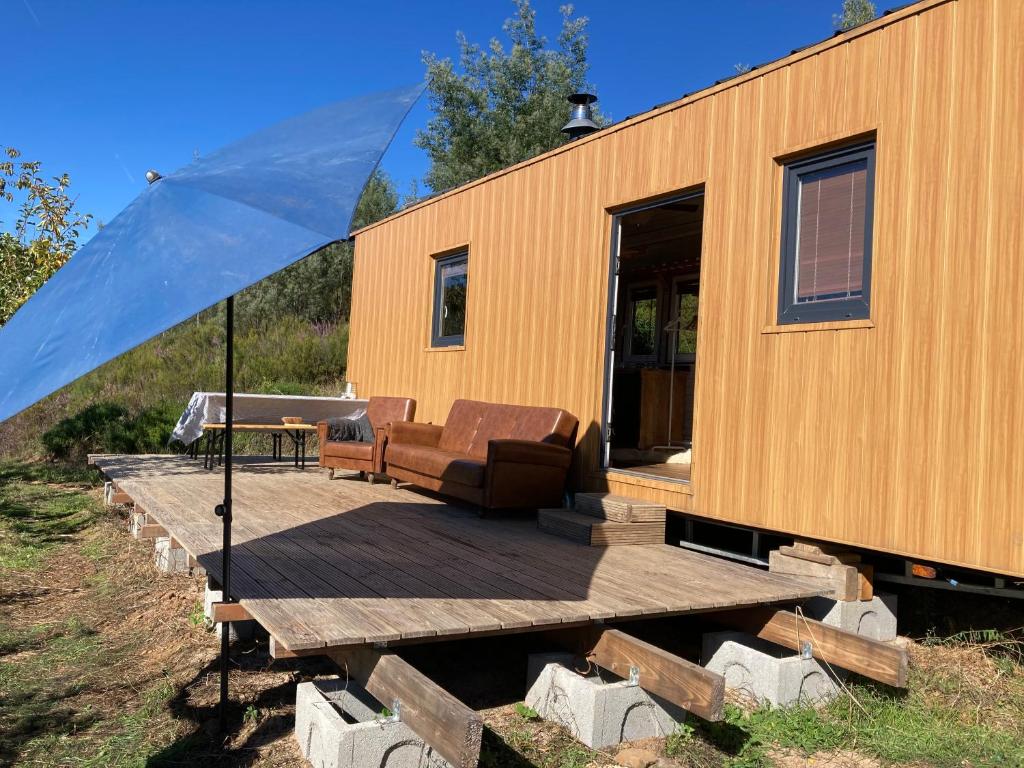 a tiny house sitting on a wooden deck at Jardim Dos Mil Gostos Covões in Sertã