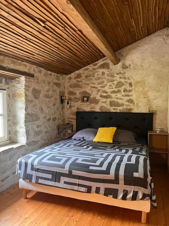 a bedroom with a bed in a stone wall at Gîte les Pieds dans l&#39;eau bord de Sèvre, 10 min du Puy du Fo in Treize-Vents