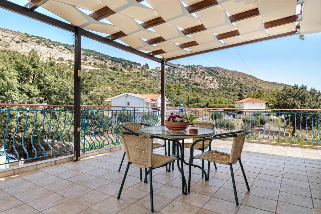 a table and chairs on a patio with a view at Spyros apartment in Markópoulon
