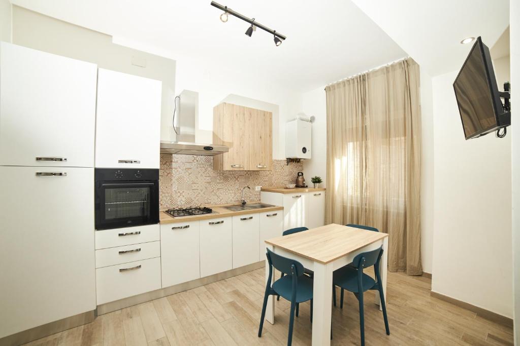 a kitchen with white cabinets and a table and chairs at Appartamento Felicia in Castel di Sangro