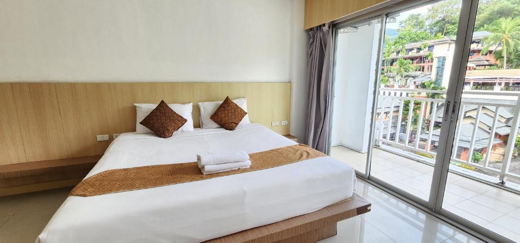 a bedroom with a large bed and a large window at Eden Park in Patong Beach