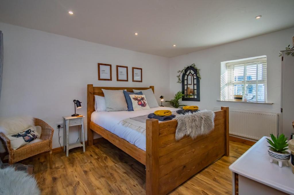 a bedroom with a wooden bed with a wooden floor at Cosy Farm Conversion In The Heart Of Pembrokeshire in Pembrokeshire