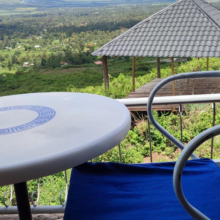 a white table and chair with a view of a field at Hillbilly Bush Lodge in Kisumu
