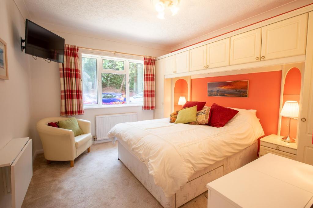 a bedroom with a bed and a chair at Cosy Annex, Close to Beach with Parking in Torquay