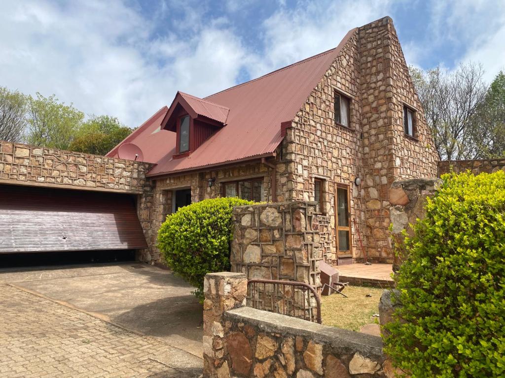 a stone house with a red roof at Critchely Stone Villa, Dullstroom in Dullstroom