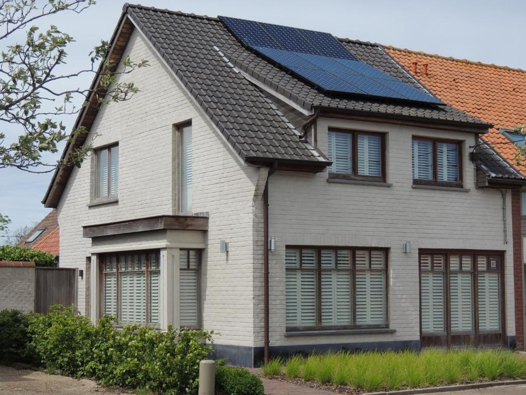 ein Haus mit Sonnenkollektoren auf dem Dach in der Unterkunft Het Heidehuis in De Haan