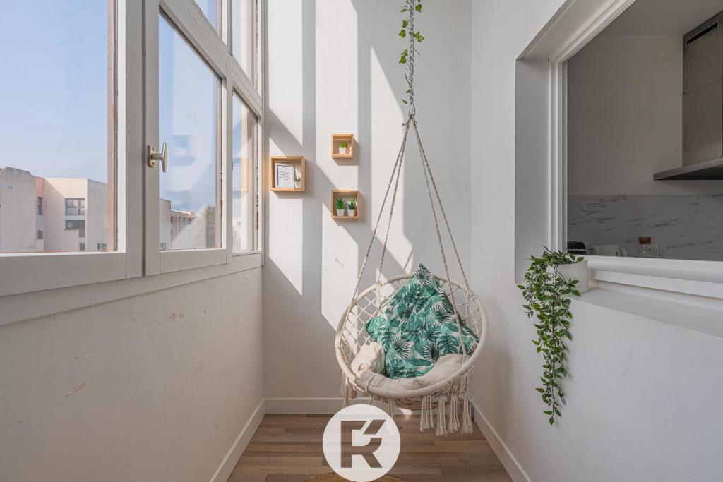 a basket hanging from a wall in a room with a window at R 'AppartsT3 Serenity Haven in Torcy