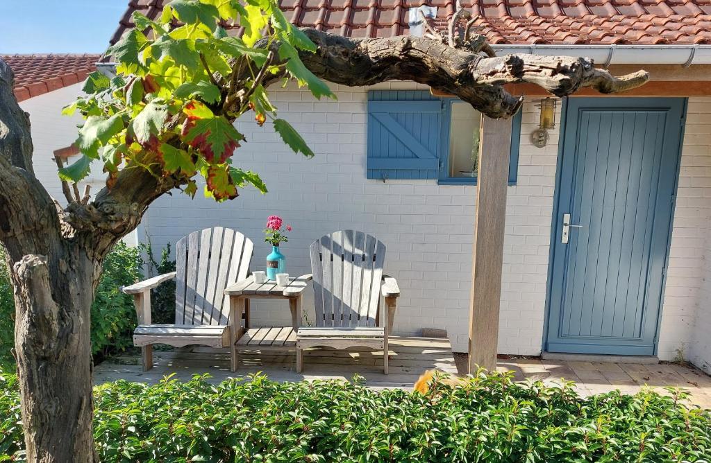 two chairs and a table in front of a house at Zeepolder I 45 in De Haan