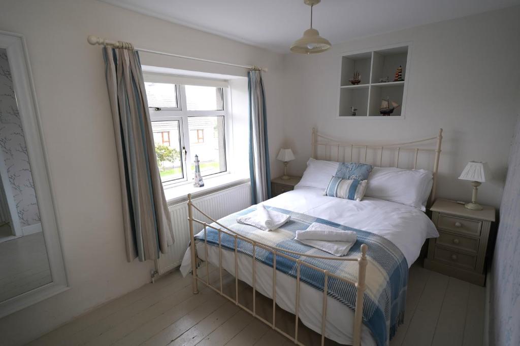 una camera con un letto con finestra e un letto sidx sidx. di Cranny Cottage Carnlough a Carnlough