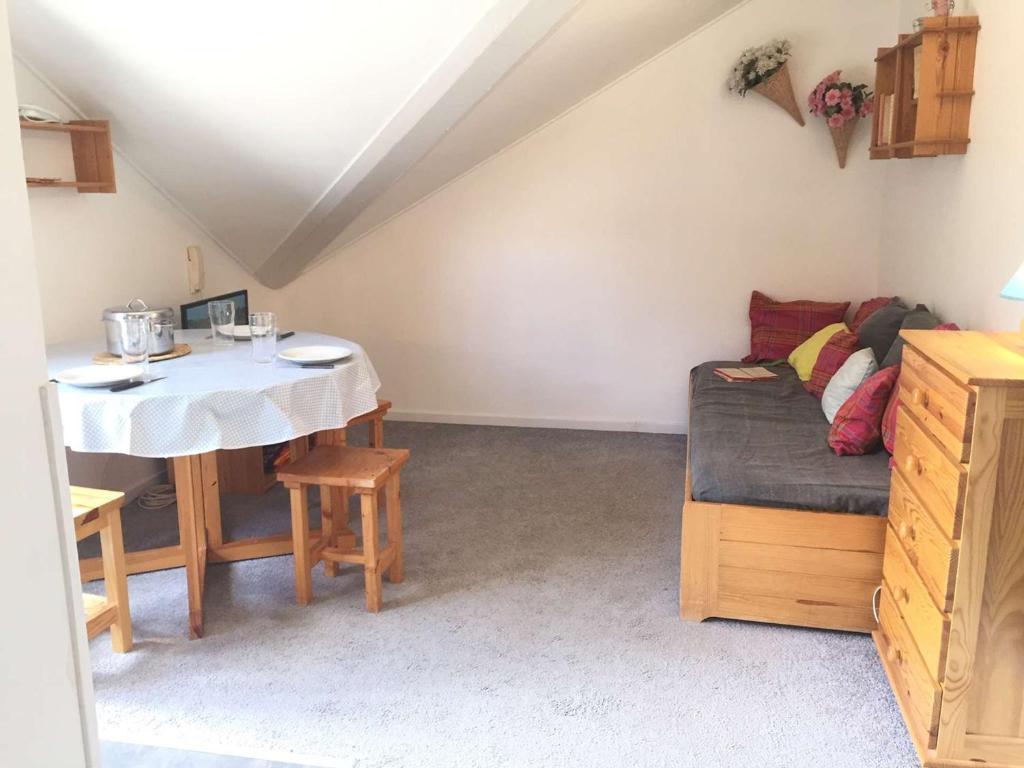 Cette chambre mansardée comprend une table et un canapé. dans l'établissement Studio Mezzanine 4 Pers, Proche Pistes et Commerces, Balcon Est, Animaux Bienvenus - FR-1-330-530, à Risoul