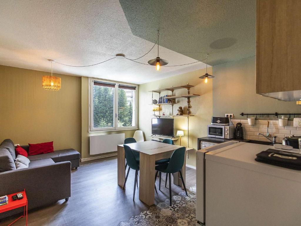 une cuisine et un salon avec une table et un canapé dans l'établissement Appartement spacieux à Gourette, 8 pers, 2 ch, entrée station, bien équipé, casier à skis - FR-1-400-113, à Eaux-Bonnes