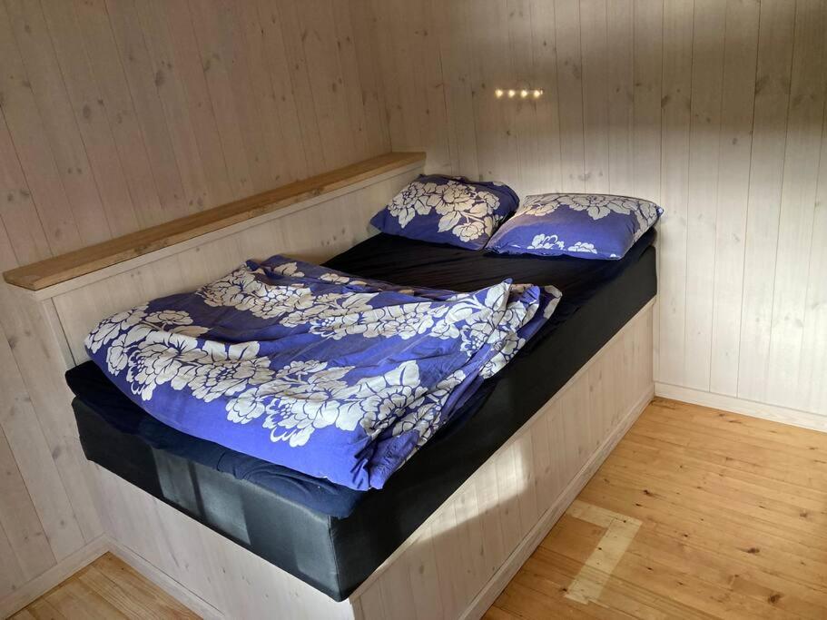 2 bedden in een kamer met een blauw dekbed bij Svingom - hytte uten strøm og vann 