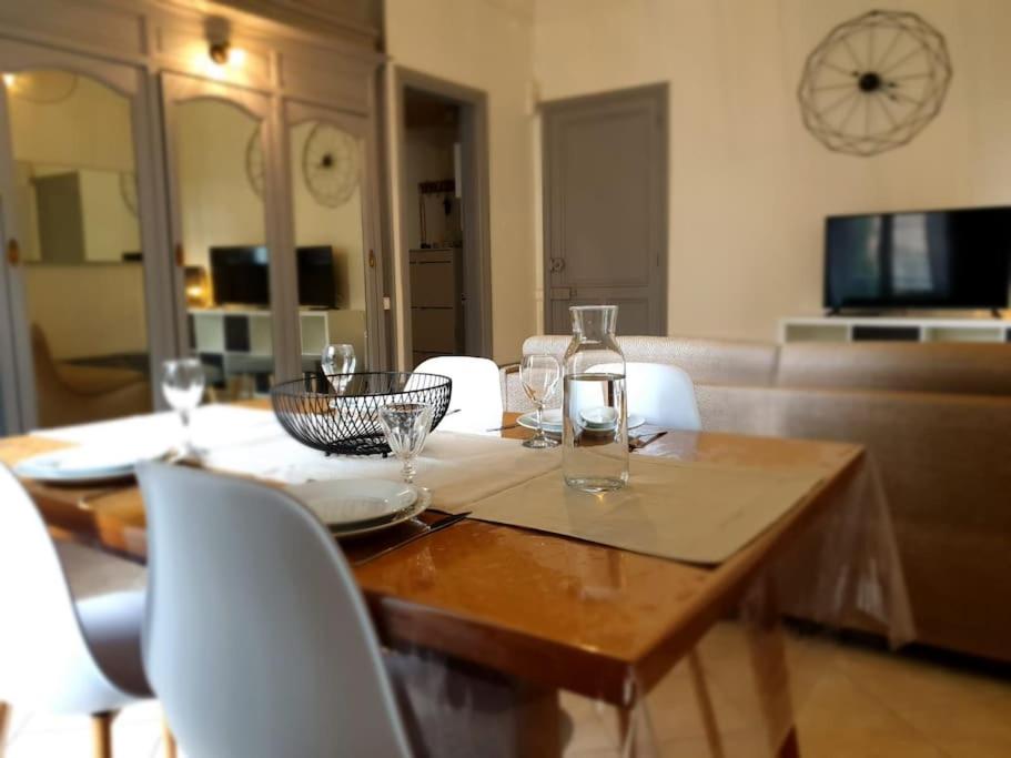 a wooden table with wine glasses on top of it at Grand T2 calme et cosy au « Pyrénées Palace » in Luchon