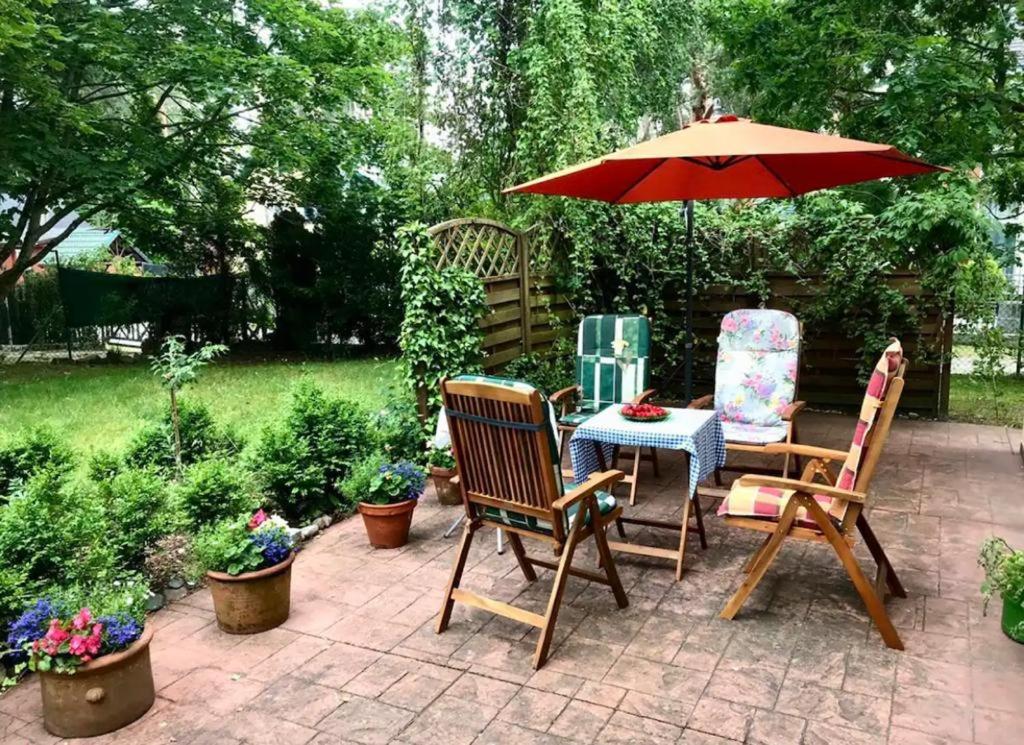 une terrasse avec 2 chaises et une table avec un parasol dans l'établissement Domek na Sosnowej, à Pobierowo
